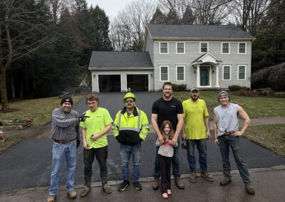 Over the Top Team standing in front a freshly paved driveway